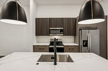 A modern kitchen with a sink and two pendant lights